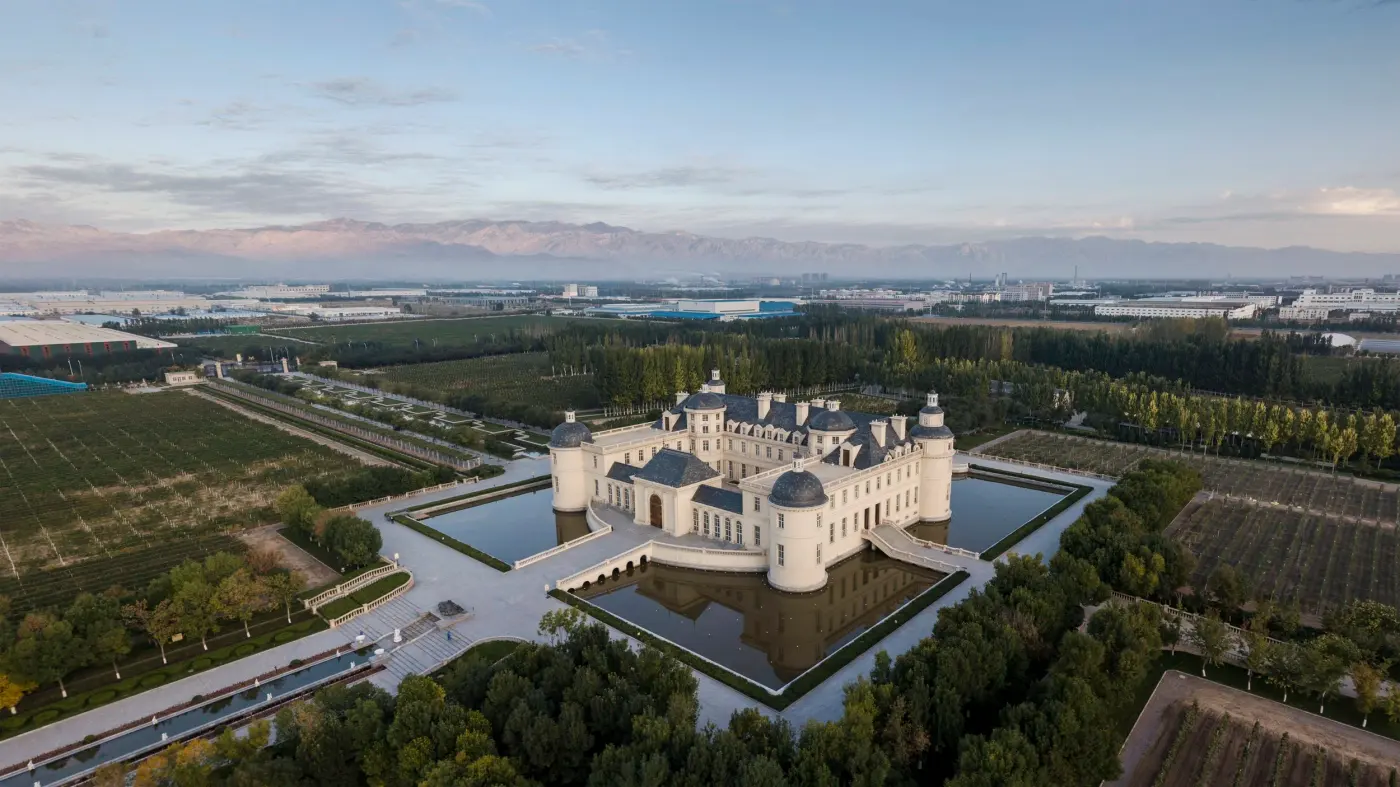 Aerial view of the château, its moat and the surrounding vineyards on the plain below the Helan Mountains